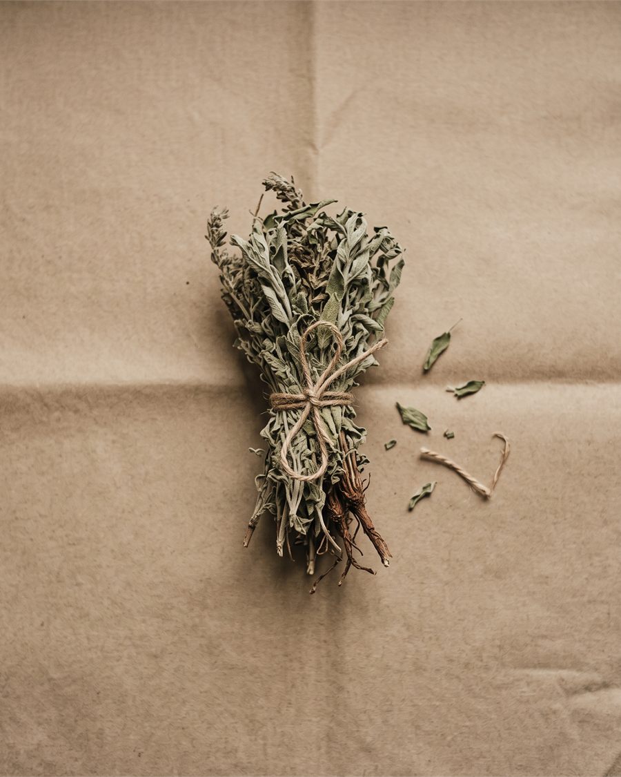 A bundle of dried herbs tied with twine on brown paper.